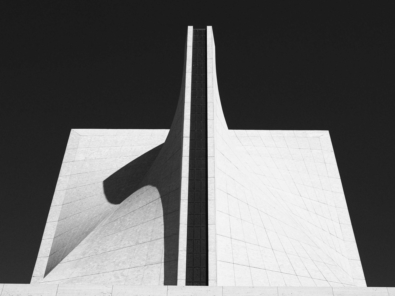 White angular concrete building against a black sky